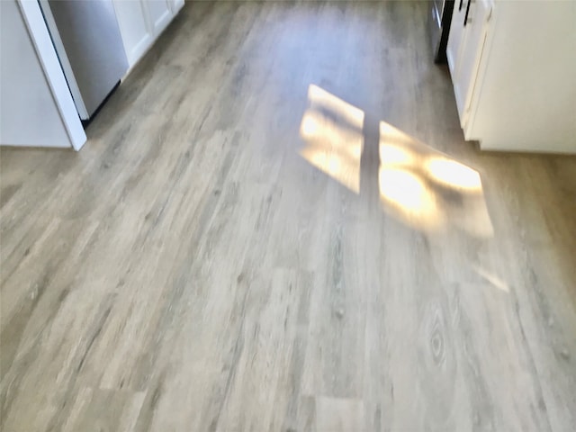 details featuring light hardwood / wood-style flooring and white cabinets