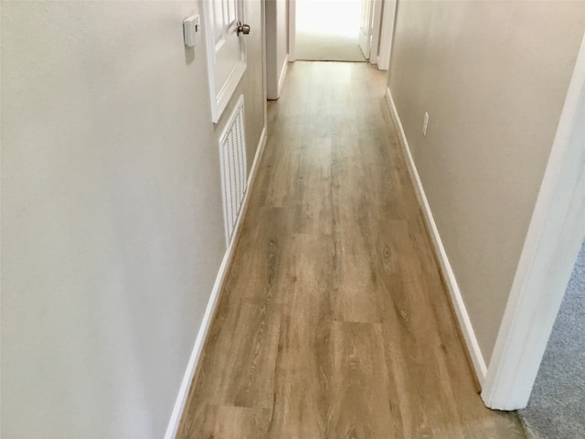 hallway with light hardwood / wood-style floors