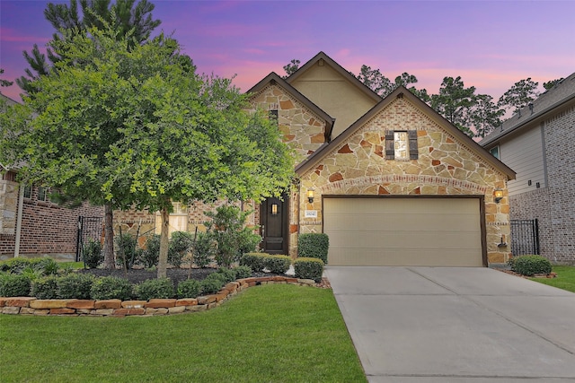 view of front of home featuring a garage and a lawn