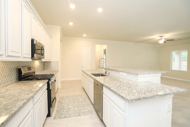 kitchen featuring decorative backsplash, a center island with sink, light tile patterned flooring, white cabinetry, and appliances with stainless steel finishes