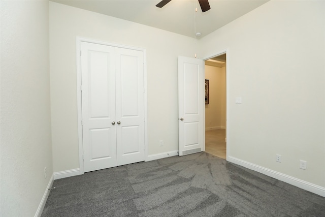 unfurnished bedroom featuring dark colored carpet, a closet, and ceiling fan