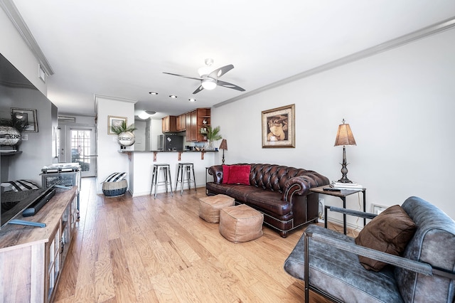 living room with ornamental molding, light hardwood / wood-style flooring, and ceiling fan