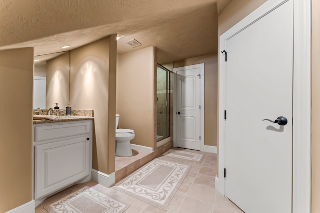 bathroom with a textured ceiling, toilet, vanity, an enclosed shower, and tile patterned flooring