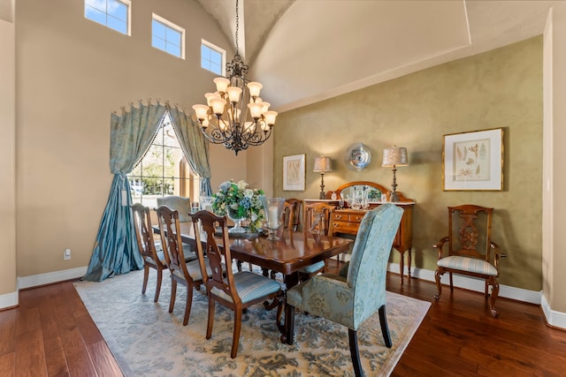 dining room with high vaulted ceiling, dark hardwood / wood-style flooring, and a chandelier