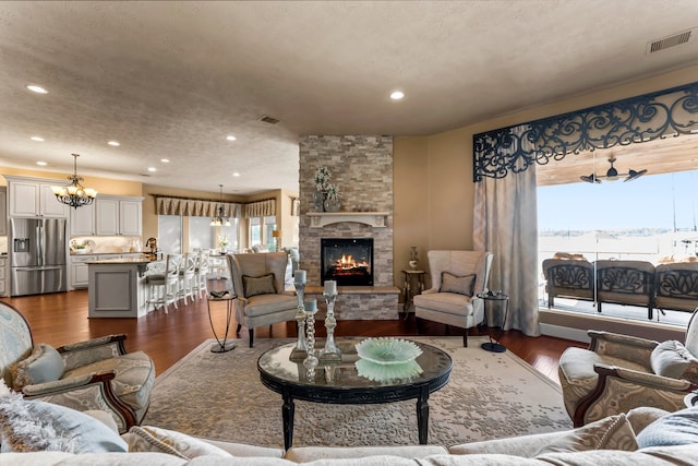 living room featuring dark wood-type flooring, a fireplace, and a textured ceiling