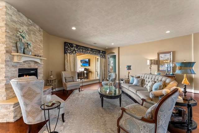 living room with hardwood / wood-style floors, a fireplace, and a textured ceiling