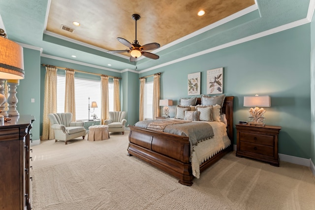 carpeted bedroom featuring ornamental molding, a tray ceiling, and ceiling fan