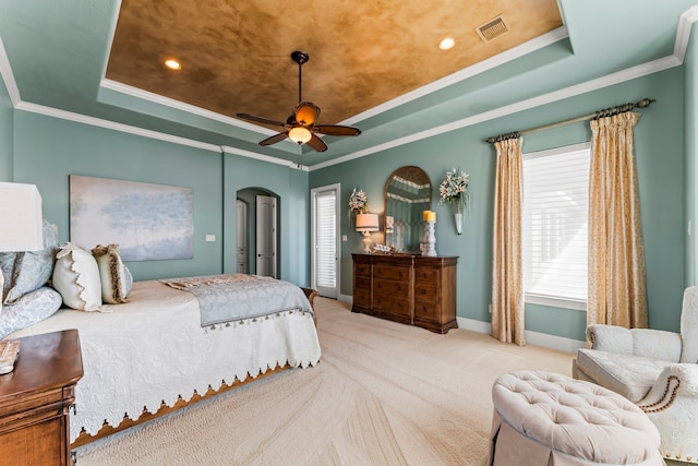 bedroom with ceiling fan, a raised ceiling, ornamental molding, and carpet floors