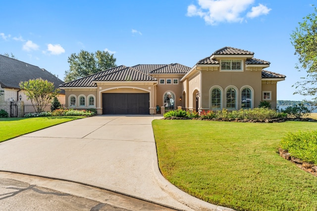 mediterranean / spanish house with a front lawn and a garage