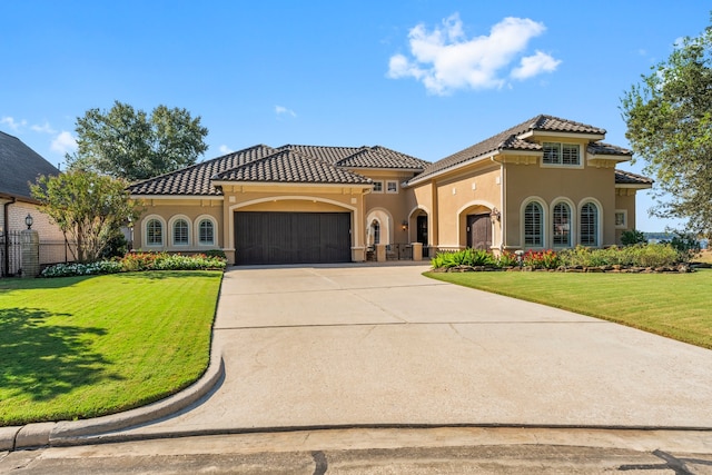 mediterranean / spanish-style house with a front yard and a garage