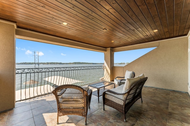 view of patio / terrace with a water view and a balcony