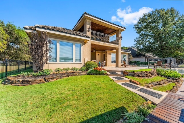 view of front of house featuring a patio area, a front lawn, ceiling fan, and a balcony