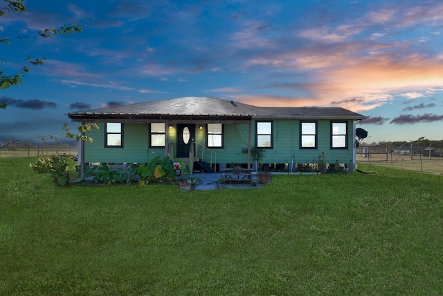 back house at dusk with a lawn