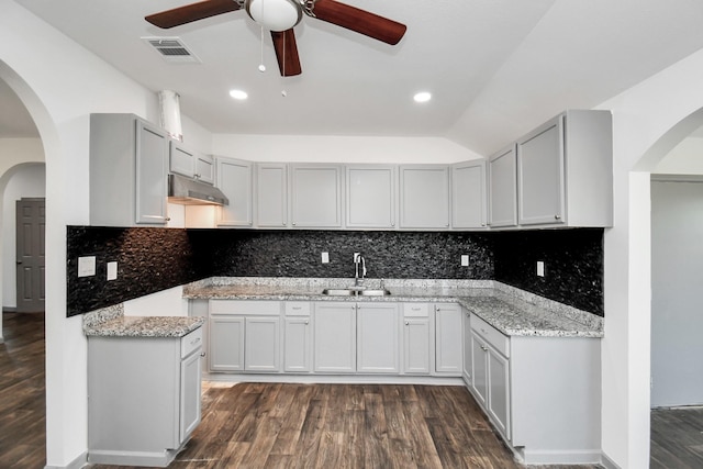 kitchen featuring light stone countertops, sink, ceiling fan, dark hardwood / wood-style flooring, and lofted ceiling