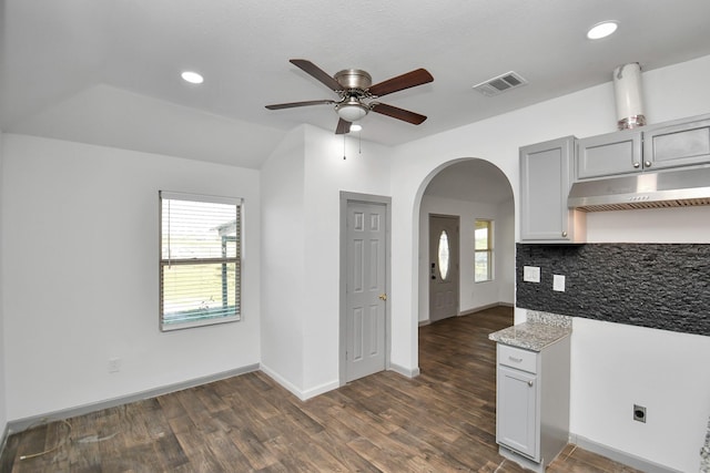 kitchen featuring dark hardwood / wood-style flooring, tasteful backsplash, vaulted ceiling, and ceiling fan