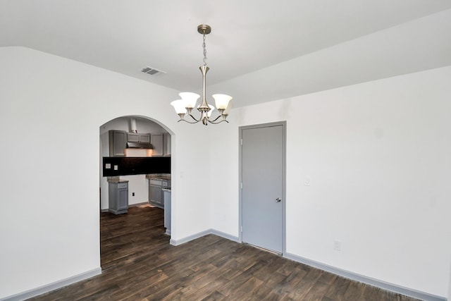 unfurnished dining area featuring vaulted ceiling, a chandelier, and dark hardwood / wood-style floors