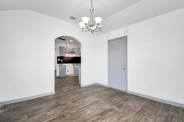 spare room with dark wood-type flooring, lofted ceiling, and a notable chandelier