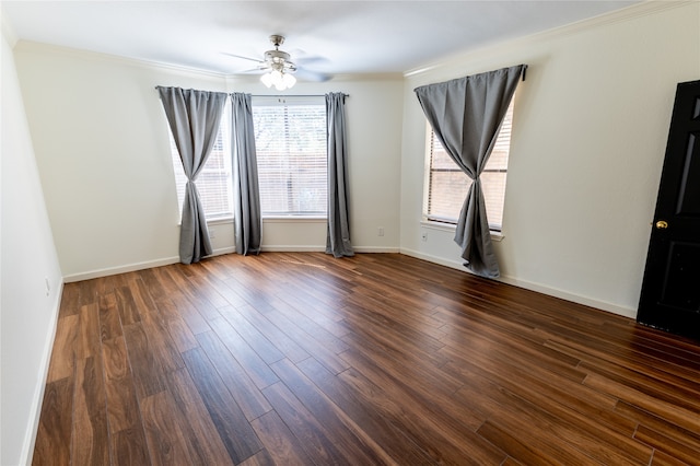 empty room featuring ceiling fan, ornamental molding, and dark wood-type flooring