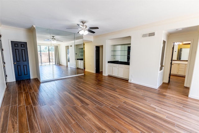 unfurnished living room with hardwood / wood-style floors, ceiling fan, and ornamental molding