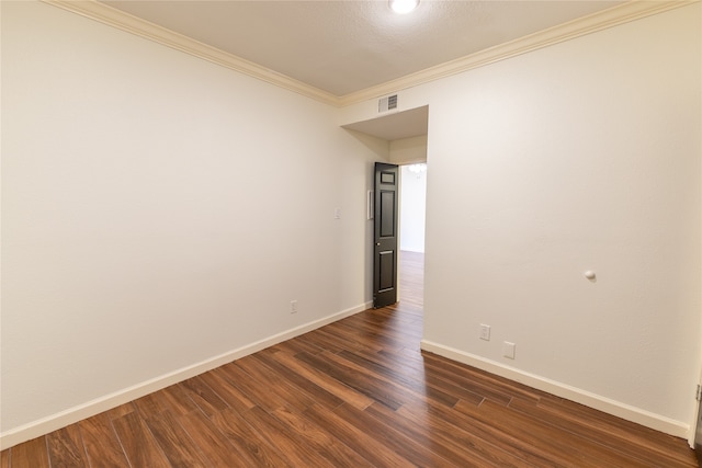 empty room featuring dark hardwood / wood-style floors and ornamental molding