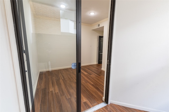 hallway featuring wood-type flooring and ornamental molding