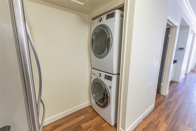 laundry area with stacked washing maching and dryer and dark wood-type flooring