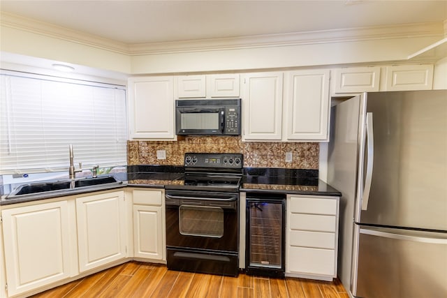 kitchen with sink, beverage cooler, backsplash, white cabinets, and black appliances