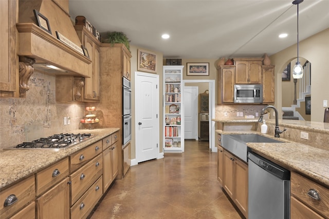 kitchen with hanging light fixtures, sink, light stone countertops, appliances with stainless steel finishes, and tasteful backsplash