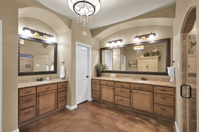 bathroom with vanity, a chandelier, a shower with shower door, and tile patterned flooring