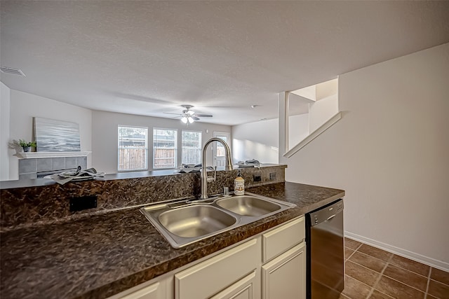 kitchen featuring sink, a textured ceiling, dark tile patterned floors, ceiling fan, and stainless steel dishwasher