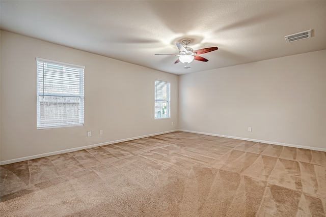 unfurnished room featuring ceiling fan, a textured ceiling, and light colored carpet