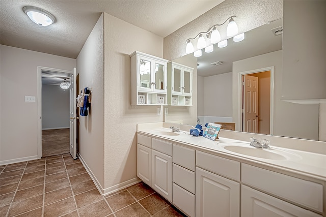 bathroom featuring vanity, a textured ceiling, and tile patterned flooring