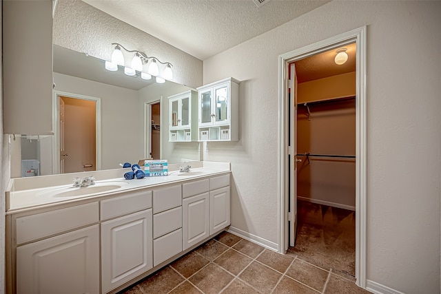 bathroom featuring vanity, tile patterned floors, and a textured ceiling