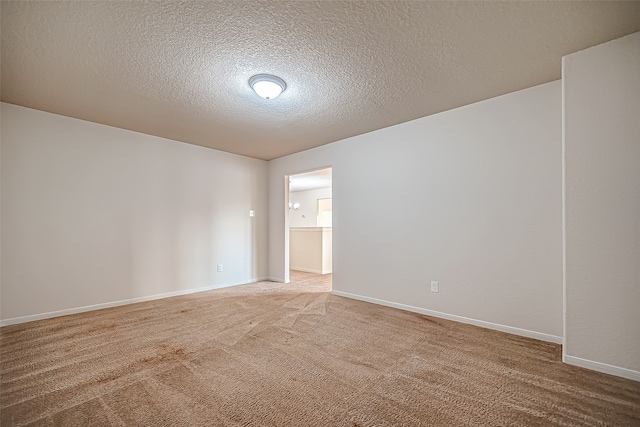 empty room with carpet and a textured ceiling