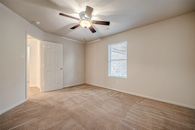 carpeted empty room with ceiling fan and a textured ceiling