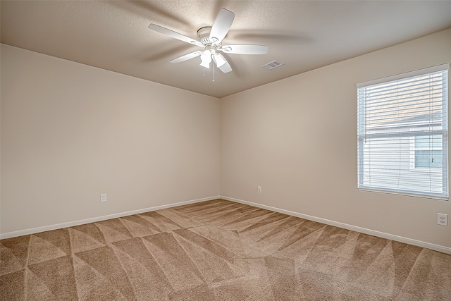 carpeted spare room featuring a textured ceiling and ceiling fan