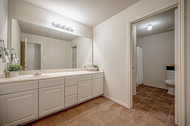 bathroom with toilet, tile patterned flooring, a shower with curtain, vanity, and a textured ceiling