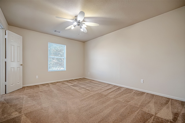 empty room featuring a textured ceiling, carpet floors, and ceiling fan