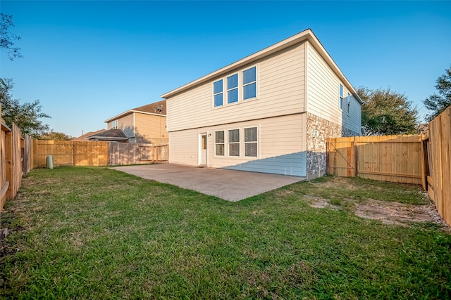 rear view of property with a yard and a patio area