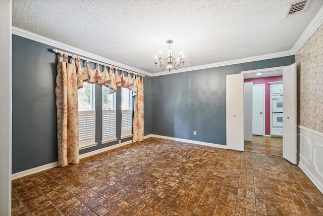 spare room featuring crown molding, a textured ceiling, and an inviting chandelier