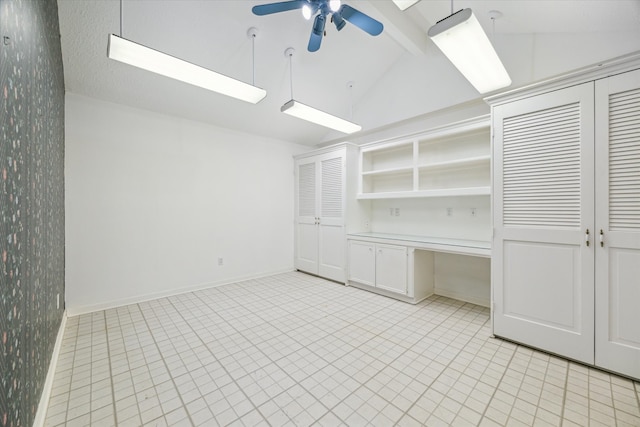 interior space with lofted ceiling, built in desk, and ceiling fan