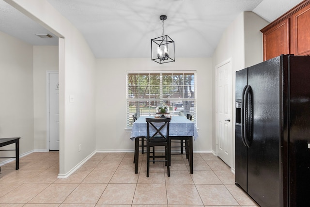 dining space with a notable chandelier, light tile patterned flooring, and lofted ceiling