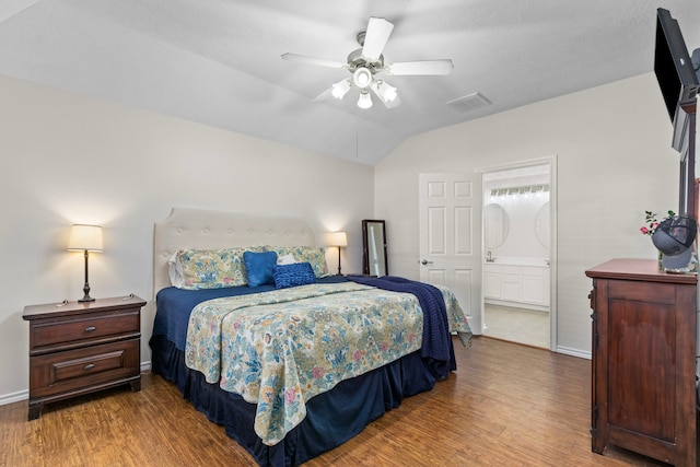 bedroom featuring hardwood / wood-style flooring, connected bathroom, vaulted ceiling, and ceiling fan