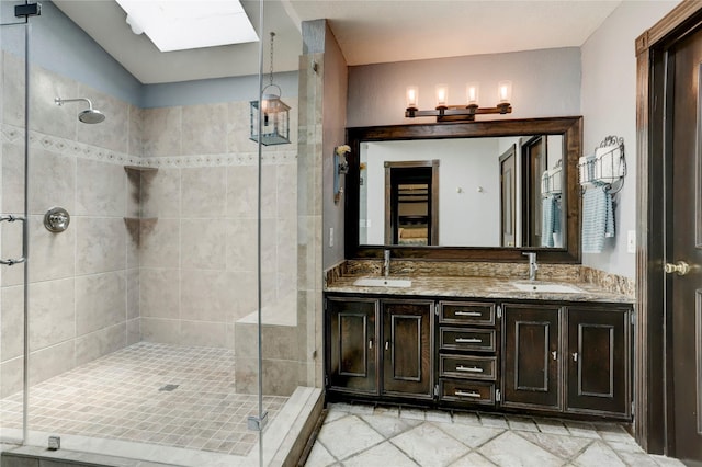 bathroom with vanity, a skylight, and walk in shower