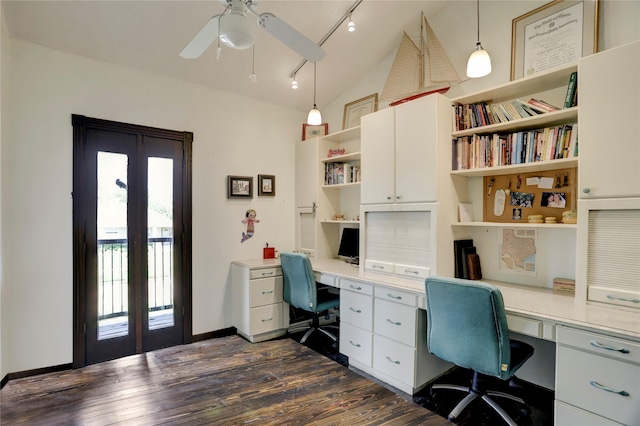 office space with ceiling fan, dark hardwood / wood-style flooring, built in desk, and vaulted ceiling