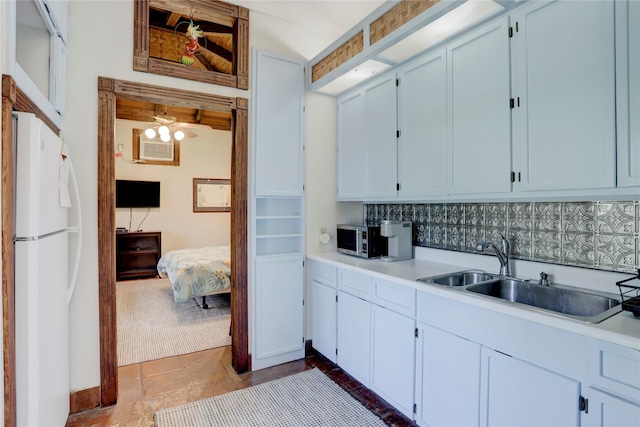 kitchen featuring white fridge, white cabinetry, tasteful backsplash, and sink