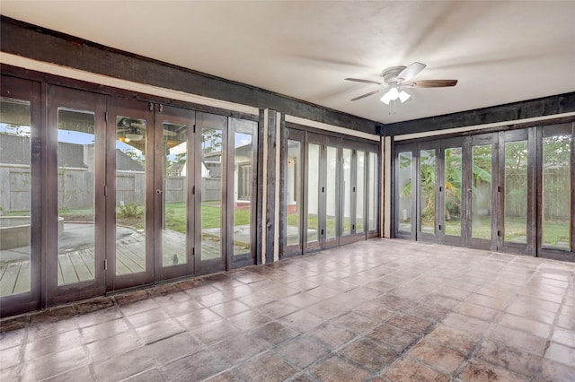 unfurnished sunroom featuring ceiling fan