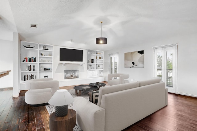 living room with dark hardwood / wood-style flooring and a textured ceiling