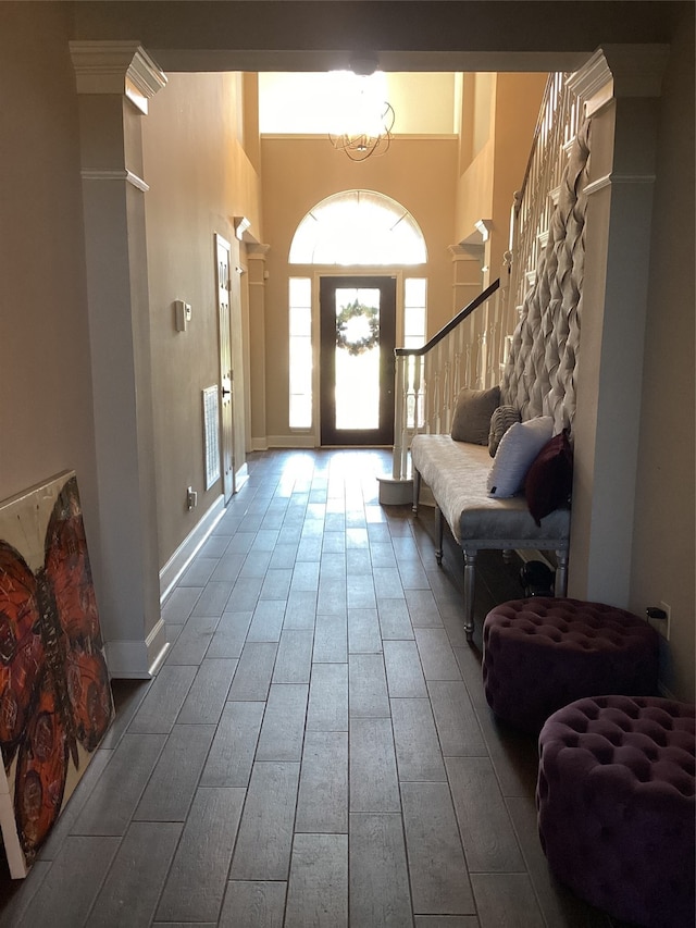 entryway featuring a towering ceiling, an inviting chandelier, and hardwood / wood-style floors