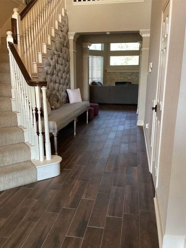 corridor featuring dark wood-type flooring and a towering ceiling